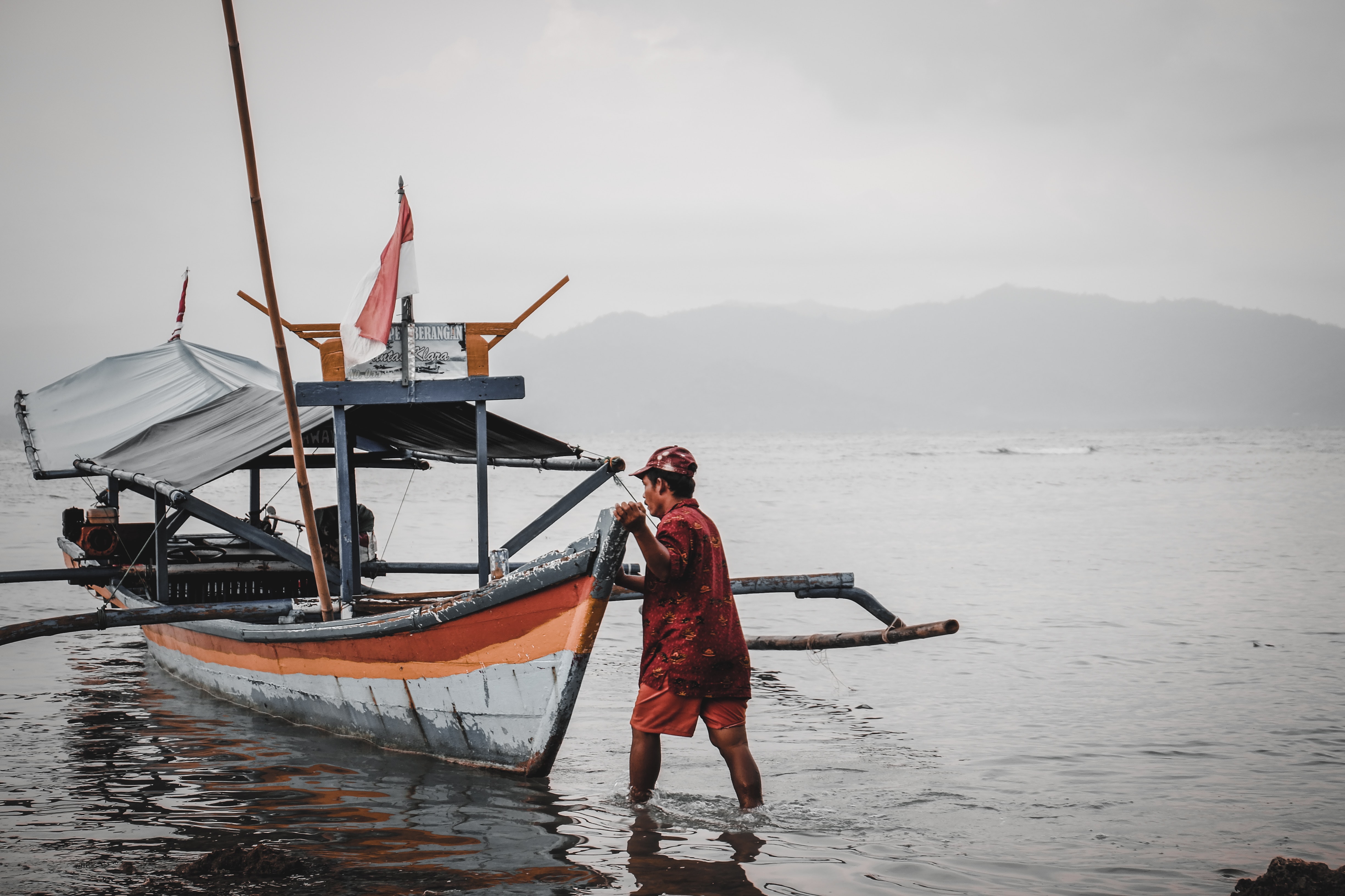 indonesian fisher pushing boat