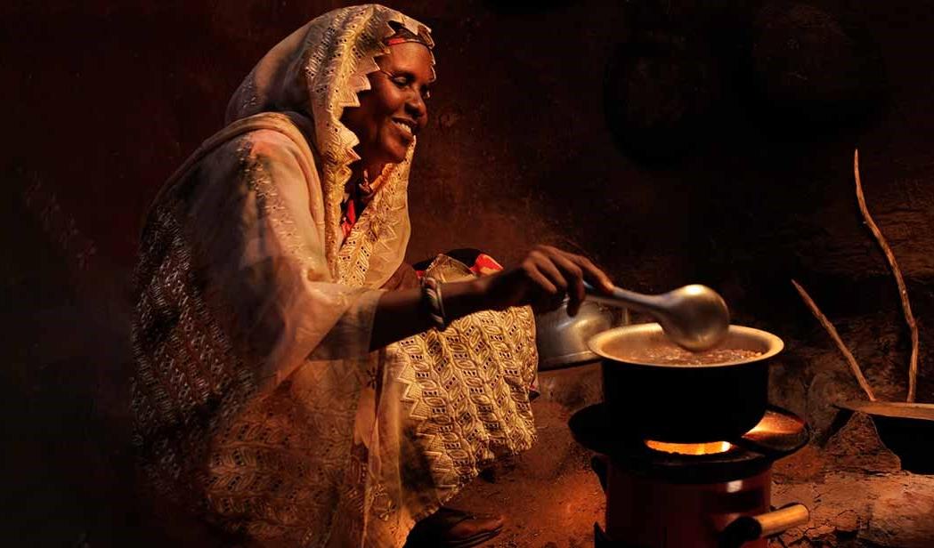 Woman cooks over stove