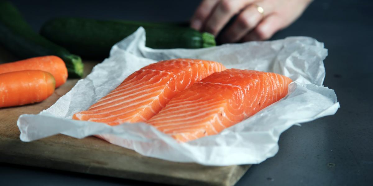 hand cutting slices of salmon