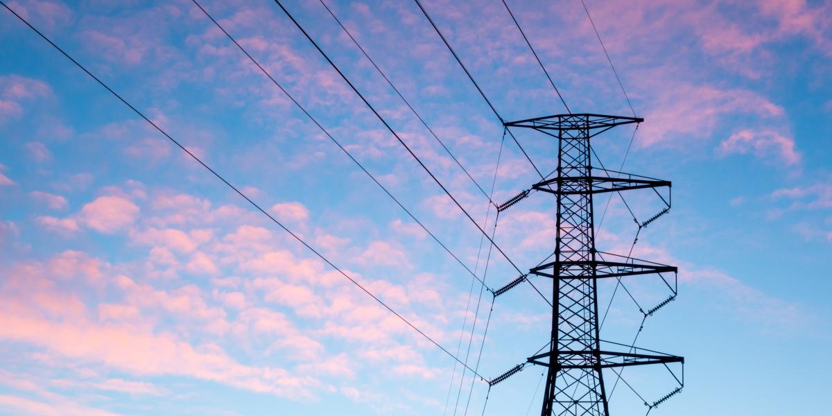 an image of powerlines in the foreground of a pink and blue sky