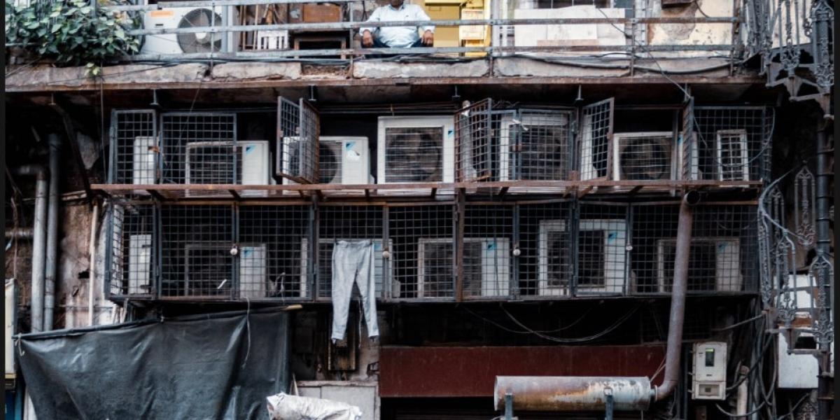 a wall of air derelict conditioning units in an alleyway