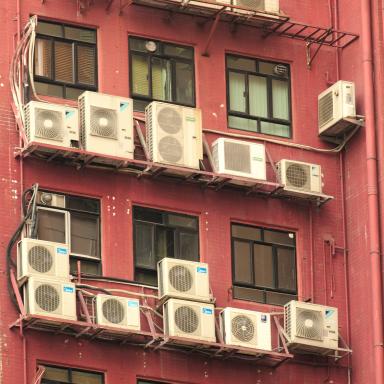 Air conditioning units on red apartment building wall