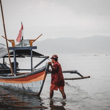 man pushing fishing boat 