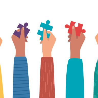 people's hands holding puzzle pieces