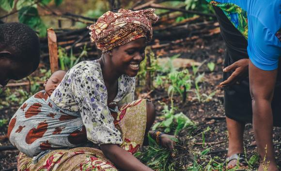 woman farming with baby on her back